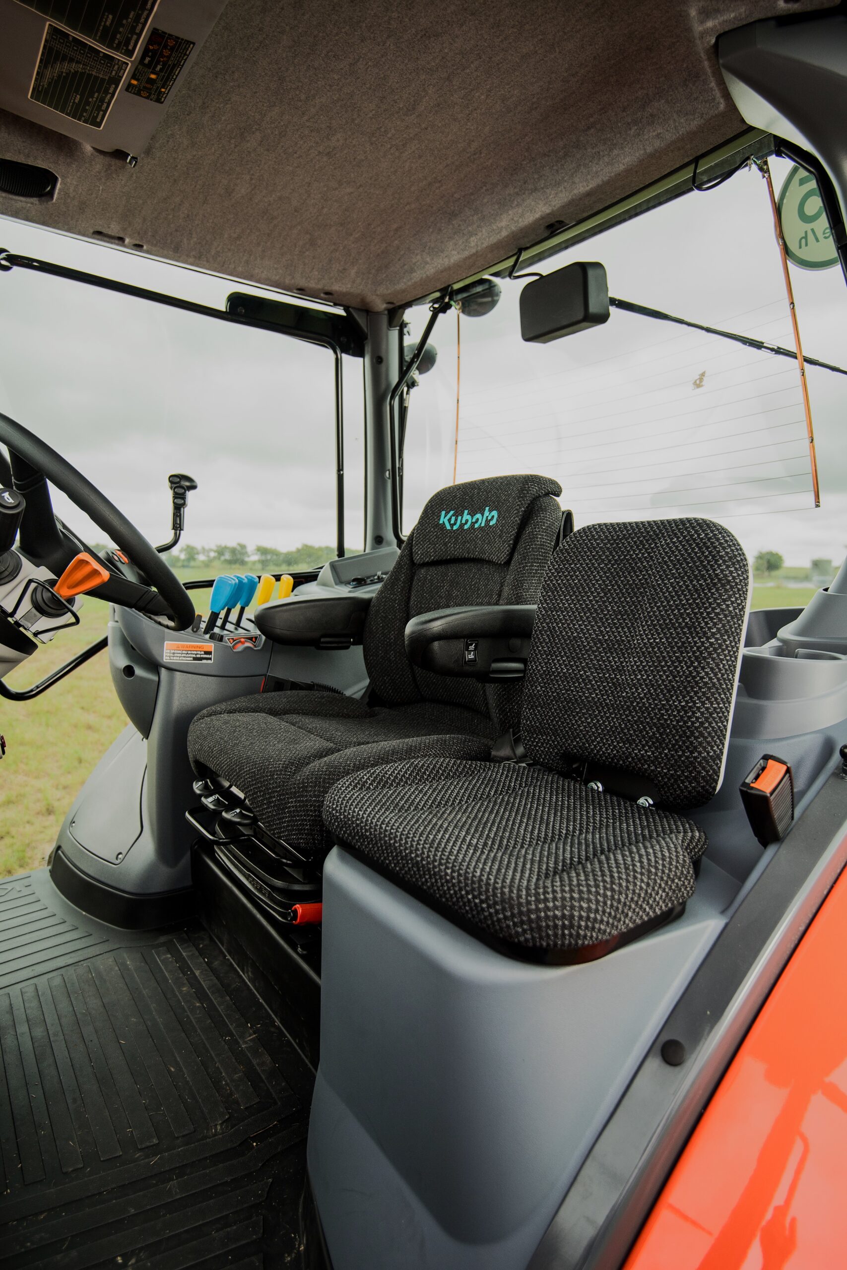 Kubota M7 cab interior with ergonomic controls and air ride seat